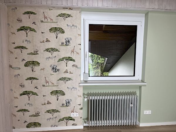 Tapezieren einer Mustertapete im Kinderzimmer